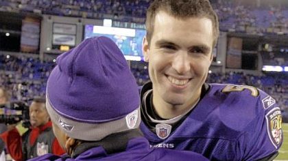 Baltimore Ravens quarterback Joe Flacco, right, gets a hug from an unidentified member of the Ravens staff.