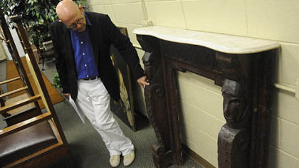 Graham Shearing points out an African-American folk art mantel made in the 1880s. It features carved pilasters, with faces over fish scale decorated scrolls and a marble top.