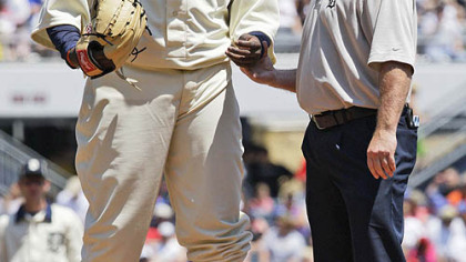 Tigers starting pitcher Dontrelle Willis, left, has his hand checked by trainer Kevin Rand in the second inning. Willis walked eight in 32/3 innings.