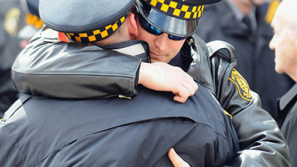 Friends and family of the slain officers watch as their caskets enter the City-County Building yesterday.