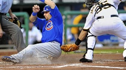 The Cubs' Jake Fox slides safely into home in the second inning as Jason Jaramillo cannot apply the tag in time because center fielder Andrew McCutchen's throw was high.