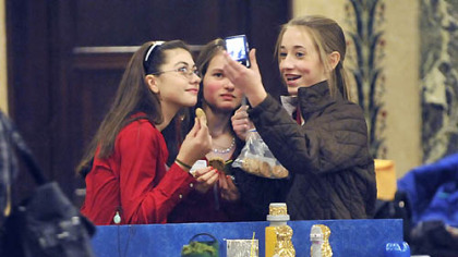 Rebecca Sellers, right, 13, takes a photo of herself with colleagues Anna Phillips, left, 13, and Samantha Dowd, 14, at the Pittsburgh Regional Future City competition, held at the Carnegie Music Hall in Oakland. The girls are eighth graders at Triadelphia Middle School in Wheeling, West Virginia, and their project is called "Land of Untapped Renewable Energy."