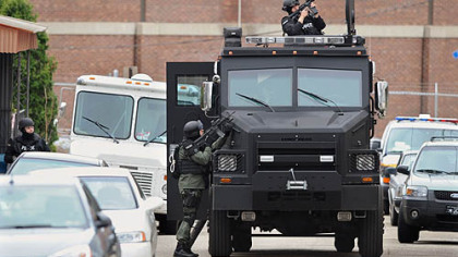Pittsburgh SWAT officers take position during a standoff in Lawrenceville on Wednesday. A juvenile was taken into custody at a house in the 3800 block of Howley Street.