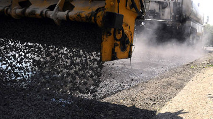 The "chipper" applies a layer of gravel over a hot steaming coating of the E-3 modified  oil on the surface  of East Willock Road in Whitehall last week.