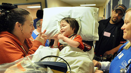 Transplant patient Oliver Wilhelm III, 5, of Kingwood, W.Va., gives a thumbs-up to his mom, Crystal at the old Children's Hospital in Oakland before he was being transferred to the new hospital this morning. He is among 178 patients being transported to the new Lawrenceville location.  At right is registered nurse Christin Cooper and Oliver's father, Oliver Wilhelm, Jr.