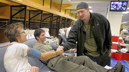Steelers defensive end Aaron Smith thanks blood donors Jesse Profota, left, of McKees Rocks, and Rich Maenza, of Wexford, during the Steelers Locker Room Blood Drive Dec. 26. Smith's 5-year-old son, Elijah, was diagnosed in Oct. 2008 with leukemia and requires blood transfusions as part of his treatment.