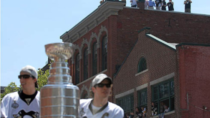 From a rooftop along the Boulevard of the Allies, fans watch Marc-Andre Fleury and Sidney Crosby pass by with the Stanley Cup.