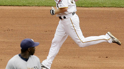 Pirates outfielder Brandon Moss rounds the bases after hitting the game-winning walk-off home run as Brewers shortstop Bill Hall walks off the field in the ninth inning.
