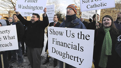 About 200 Duquesne University students, including law students Vince Thompson (left) and Jeff Bannek (center), demonstrate on campus yesterday afternoon against university President Charles Dougherty and the university's decision to remove Don Guter as law school dean.