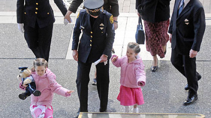 The family of slain Officer Stephen J. Mayhle ? widow Shandra, rear second from left, and daughters Jennifer, 6, and Brooklynn, 3 ? arrives for the final viewing at the City-County Building yesterday.