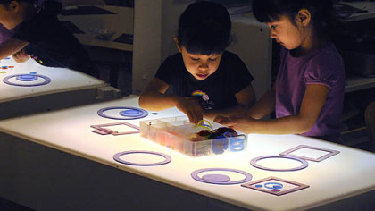 Four-year-old twins Uma and Jayanthi Simhan work on a light table with different shapes at Shady Lane School in Point Breeze.