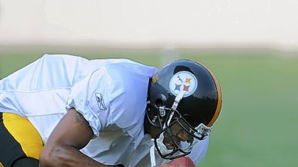 Quarterback Dennis Dixon ducks as a blocking pad thrown by quarterbacks coach Ken Anderson goes sailing over his head.