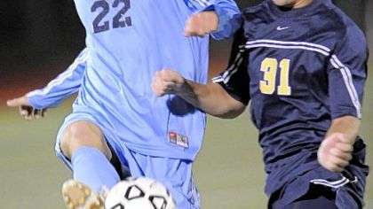 Mt. Lebanon's Evan Schardt, left, beating Kiski Area's Mike Geiselhart to the ball during a WPIAL playoff match last season, leads the defense for top-ranked Blue Devils.