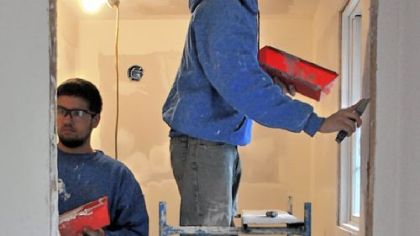 Michael Jones, left, and Jonathan Probst, both of Deer Lakes, finish the drywall in the master bathroom.