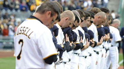 Led by manager John Russell, Pirates players observe a moment of silence in memory of three fallen police officers during Opening Day ceremonies yesterday at PNC Park.