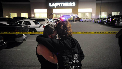 Theresa Smith, left, 18, and friend Ashley Slifko, 19, embrace outside LA Fitness last night in Collier. Ms. Smith?s sister, Tracey, was inside during the shooting but escaped unharmed.