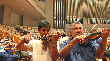 Violinst Christopher Wu (left) and concertmaster Andres Cardenes warm up with other members of the Pittsburgh Symphony at the
National Centre for the Performing Arts in Beijing.