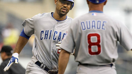 Cubs first baseman Derrek Lee rounds third to greetings from coach Mike Quade after hitting a solo homerun off Pirates pitcher Daniel McCutchen during the first inning.