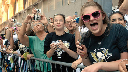 Fans cheer the Penguins as they parade along Grant Street.