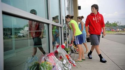 From left, Amanda Tirmble, 13, Elizabeth Scurich, 13, and Zach Young, 14, look into the entryway of Bridgeville's LA Fitness, the site of the fatal shooting of three woman, the day after it occurred.