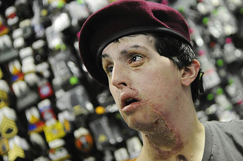 Kevin tries on a maroon beret from his unit He was a member of the