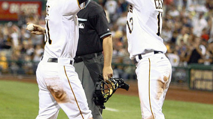Pirates pinch hitter Steve Pearce, left, is greeted at home plate by teammate Ronny Cedeno after driving Cedeno in during the sixth inning. Pearce''s hit drove in Cedeno and Pearce scored on an error.