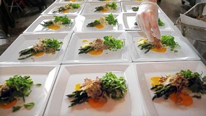 The finishing touches are put on the asparagus salad at the "underground" dinner by chef Kevin Sousa.