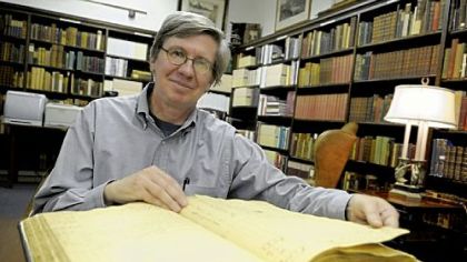 Amateur historian Michael Shealey with the Old Stone Tavern ledger from 1793 to 1796 in the William R. Oliver Special Collections room in the Carnegie Library, of Pittsburgh Oakland.