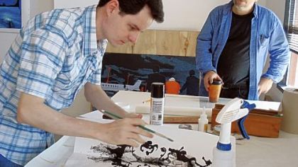 Brazilian artist Jose Rufino, who will exhibit at The Andy Warhol Museum next year, working at Artists Image Resource on the North Side. With him is AIR's Robert Beckman.