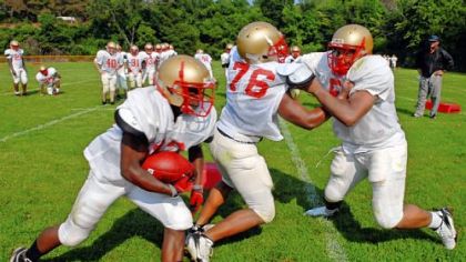 Penn Hills defensive lineman Aaron Donald, right, sheds his blocker and goes for the running back in the Oklahoma drill on the first day of practice last week.