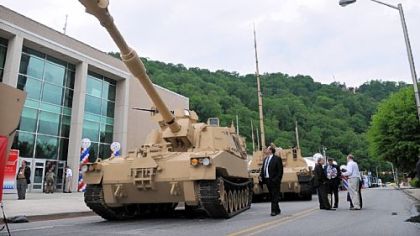 Visitors look over the display of vehicles by BAE Systems at the Showcase for Commerce at the Cambria County War Arena in Johnstown.  Among them is this Paladin Integrated Management vehicle.