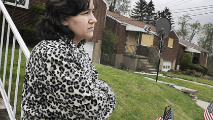 Fear continues to haunt Maysaa Chok a month after the violence that took place at her next door neighbor's home, which still has plywood covering the doors and windows. Bullet holes remain in Ms. Chok's bedroom window.