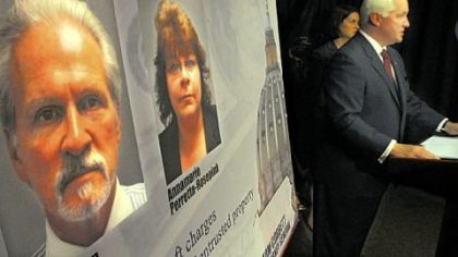 State Attorney General Tom Corbett, right, outlines the charges against Mike Veon and Annamarie Perretta-Rosepink, whose photos are mounted on the board, during a news conference yesterday.