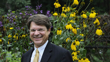 Richard Piacentini, executive director of Phipps Conservatory, brings his work home in his rain garden. Behind him are ironweed, left, and Helianthus.
