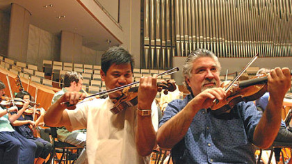 Violinst Christopher Wu (left) and concertmaster Andres Cardenes warming up with other members of the Pittsburgh Symphony at the
National Centre for the Performing Arts in Beijing.