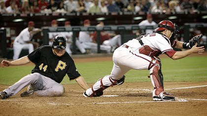 Pirates outfielder Brandon Moss scores on an RBI double by third baseman Andy LaRoche as Diamondbacks catcher Miguel Montero waits for the throw during the fourth inning.