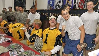 Bill Cowher, the former head coach of the Pittsburgh Steelers, poses with U.S. Air Force SRA Jonathan Echevarria at Forward Operating Base Warrior near Kirkuk, Iraq, Thursday.