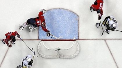 Washington goalie Simeon Varlamov makes a diving save on a shot by Sidney Crosby, right, that seemed headed for an open net late in the second period and the score tied, 2-2.
