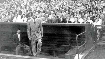 The Rev. Billy Graham emerges from the Pirates' dugout at Forbes Field to deliver a sermon in his first visit in September 1952.