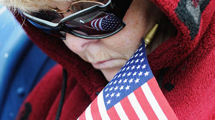 Dee Allen, of Bloomfield, bows her head during the Mass, which was broadcast through loudspeakers for mourners gathered on Liberty Avenue outside St. Joseph Church.