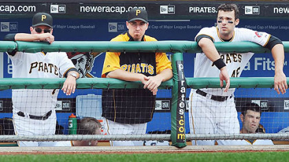 Former Pirates first baseman Adam LaRoche, middle, stands in the dugout next to manager John Russell, left, and his replacement, Garrett Jones.