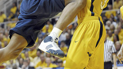 Sam Young is fouled by West Virginia forward Devin Ebanks in the second half yesterday in Morgantown, W.Va.