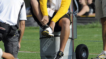 Ben winces as he puts on his right shoe.