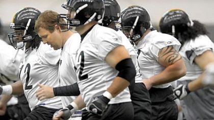 A helmet-less Steelers quarterback Ben Roethlisberger makes his way past a pack of linemen during minicamp workouts yesterday at their practice facility on the South Side. Spring drills for the Super Bowl champions will run through tomorrow.