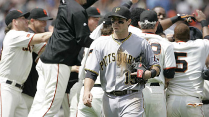 Pirates third baseman Andy LaRoche walks back to the dugout as the Giants mob outfielder Randy Winn who hit an RBI single down the first base line in the 10th inning in San Francisco yesterday. The Giants won the game, 1-0, to complete a three-game sweep.