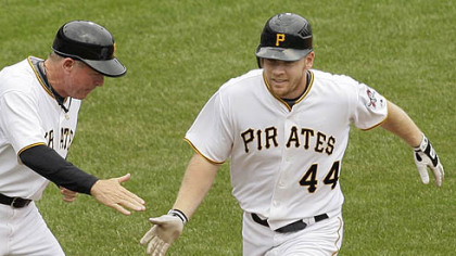 Pirates outfielder Brandon Moss rounds third to greetings from coach Rich Donnelly after hitting a game-winning walk-off solo-home run off Brewers pitcher Mitch Stetter in the ninth inning.