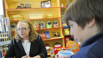 Maggi Cook, owner of the Frick Park Market in Point Breeze, takes orders for candy and slushies at the candy bar on a recent Friday.