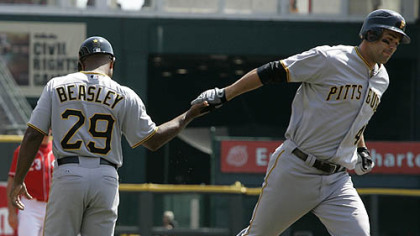 Pirates first baseman Garrett Jones is congratulated by third base coach Tony Beasley after Jones hit a solo home run off Reds pitcher Homer Bailey in the second inning of yesterday's game in Cincinnati. Jones' home run was the Pirates'' 10,000th in franchise history.