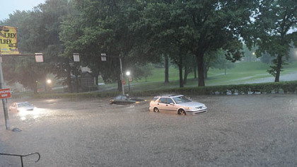 A motorist sits stranded along Forbes Avenue in Oakland, just one of the region's roadways flooded by storm water tonight.