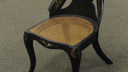 This 19th century papier-mache side chair has a molded and shaped balloon back with mother of pearl inlay and gilt decoration.